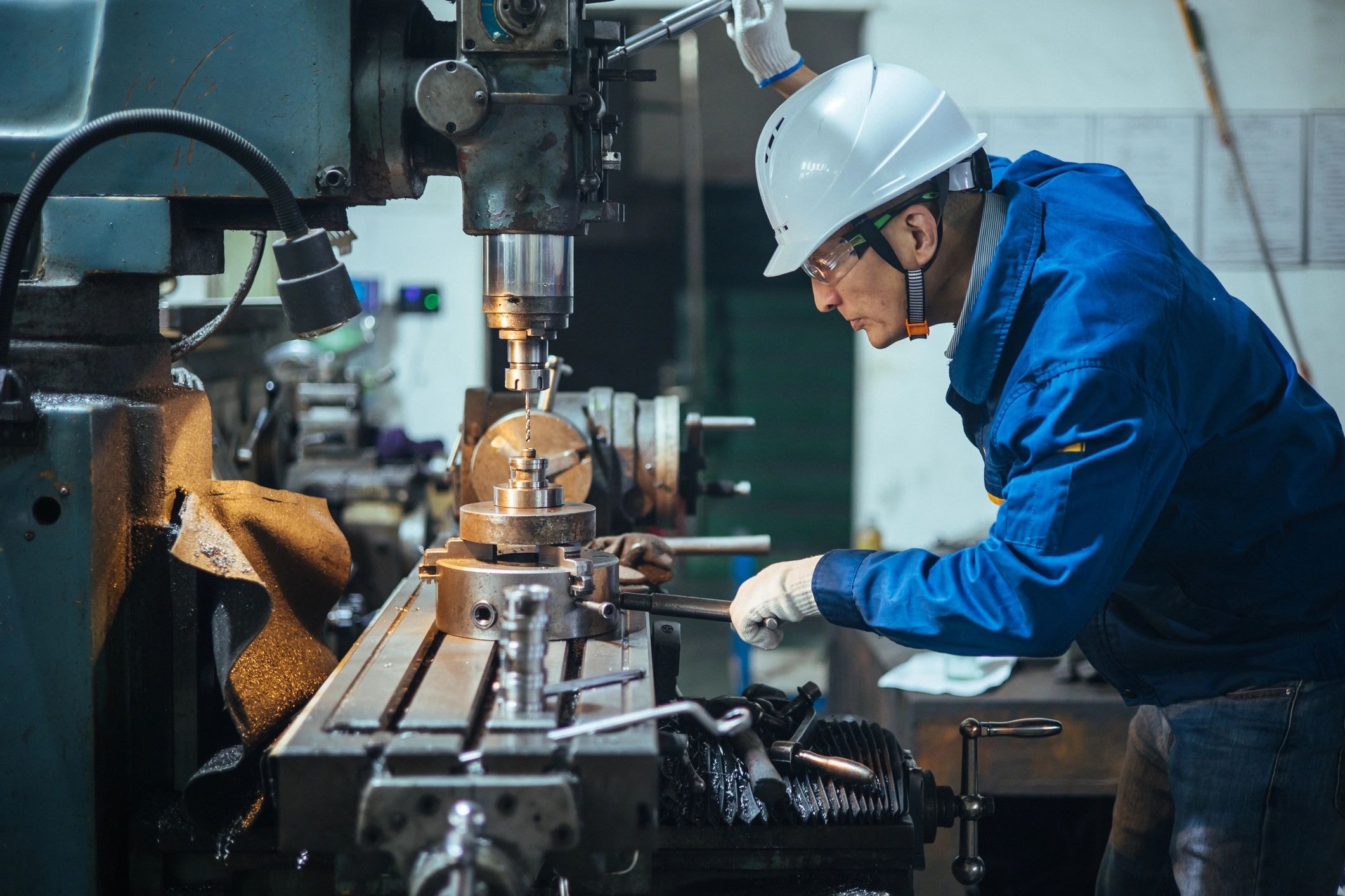 Worker operating CNC lathe